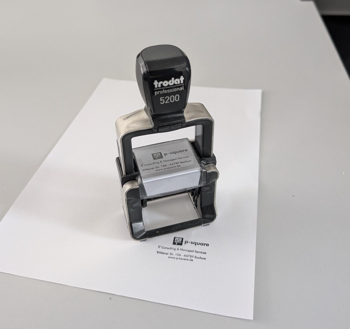 A company stamp standing on a piece of paper with the stamp applied